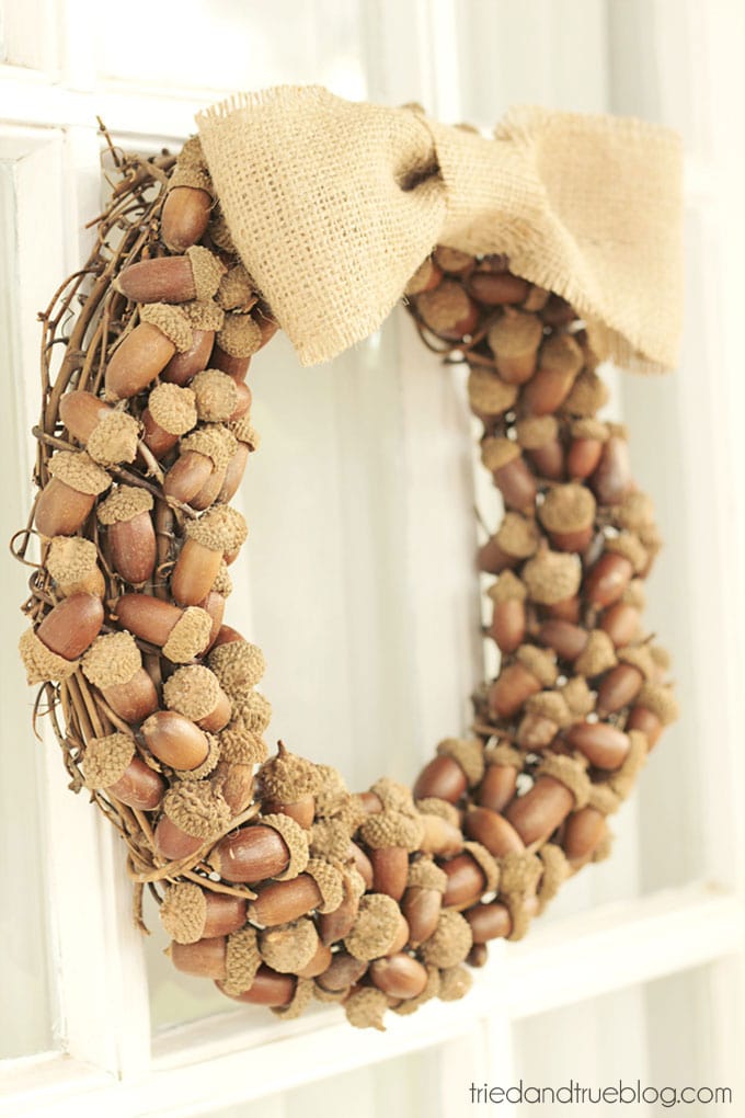 A wreath made f acorns hanging on the front door.