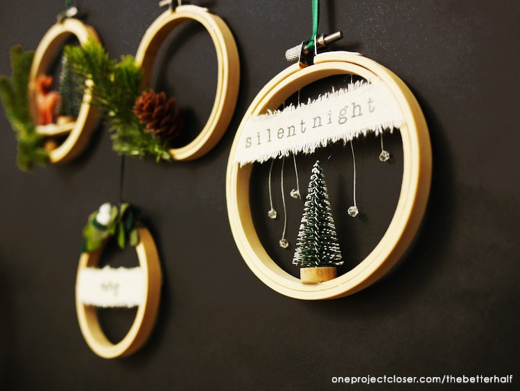 Embroidery hoops with mini trees and pine cones decorated for the holidays.