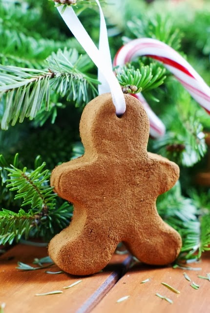 A DIY gingerbread man with a hole in the top and ribbon in the hole to be tied as an ornament.