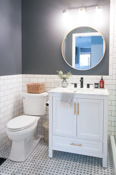 White subway tile and white vanity in bathroom with dark gray walls