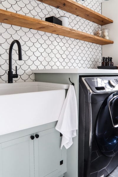 white farmhouse sink in laundry room and cabinet painted Sherwin Williams Oyster Bay