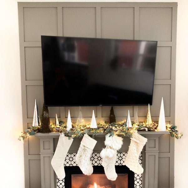 feature wall with TV and stockings hanging on the mantle